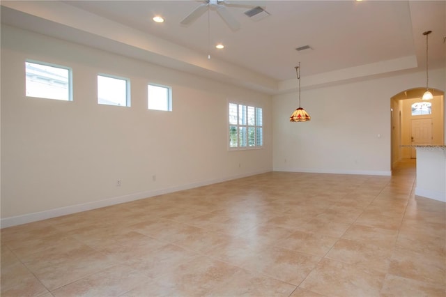 spare room with a raised ceiling and ceiling fan