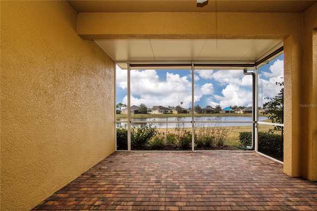 unfurnished sunroom with a water view