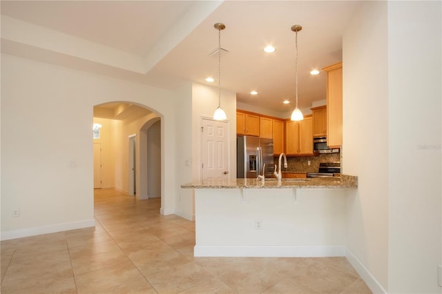 kitchen featuring sink, hanging light fixtures, appliances with stainless steel finishes, kitchen peninsula, and backsplash