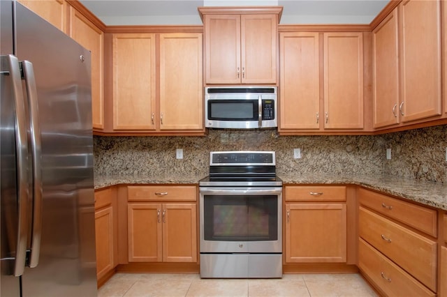 kitchen featuring backsplash, light tile patterned flooring, light stone countertops, and appliances with stainless steel finishes