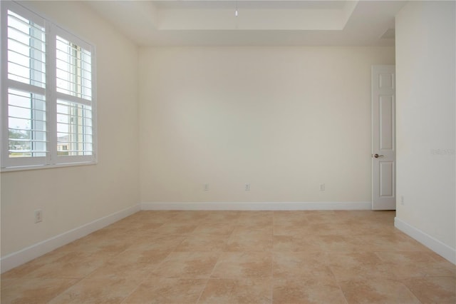 unfurnished room featuring a raised ceiling