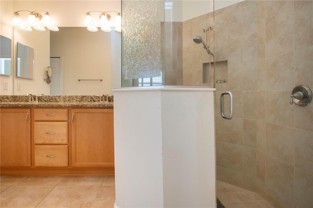 bathroom with tile patterned flooring, vanity, and a shower with door