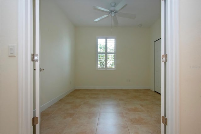 tiled empty room with ceiling fan