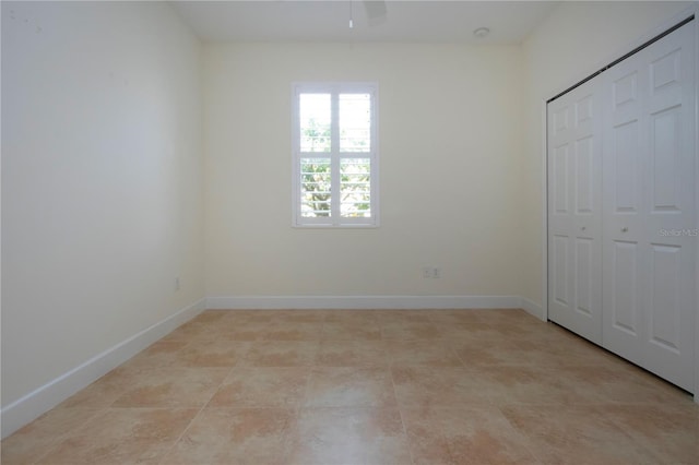 unfurnished bedroom featuring ceiling fan and a closet