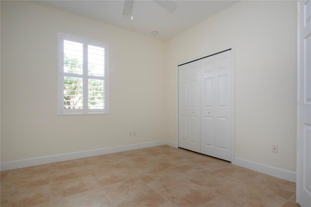 unfurnished bedroom featuring ceiling fan and a closet