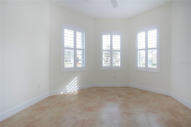 unfurnished room with light tile patterned floors and ceiling fan