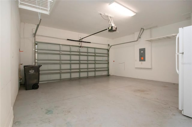 garage with a garage door opener, electric panel, and white refrigerator