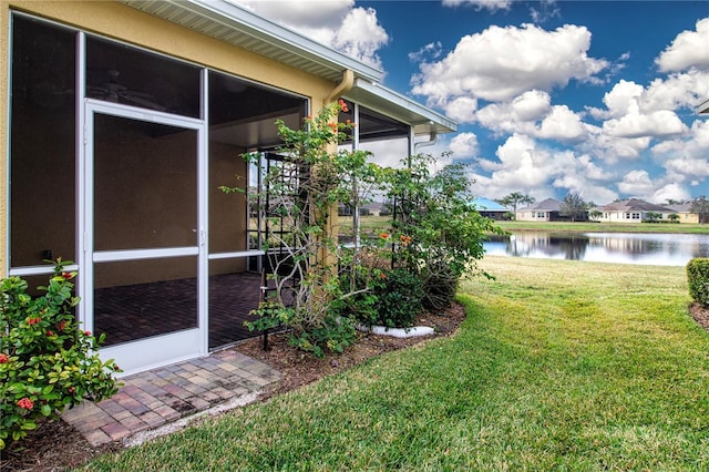 view of yard featuring a water view and a sunroom