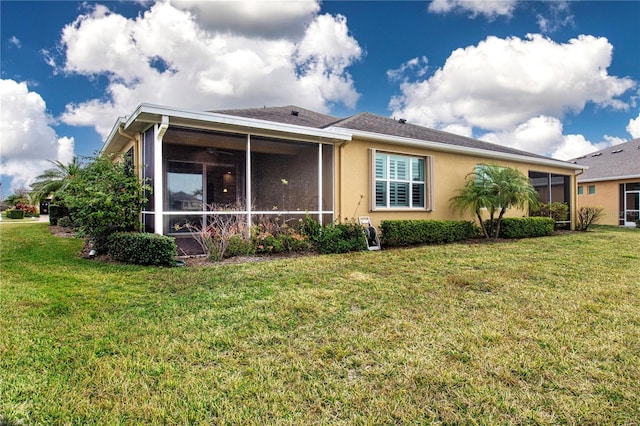 rear view of property with a yard and a sunroom