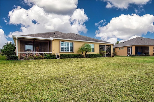 rear view of house featuring a lawn and a sunroom