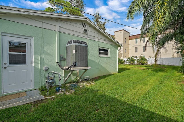 3887 50th Ave S, Saint Petersburg, FL 33711 - view of side of property featuring a lawn, stucco siding, and central AC unit
