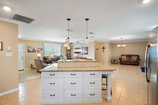 kitchen featuring a kitchen breakfast bar, stainless steel fridge, pendant lighting, light tile patterned floors, and white cabinets