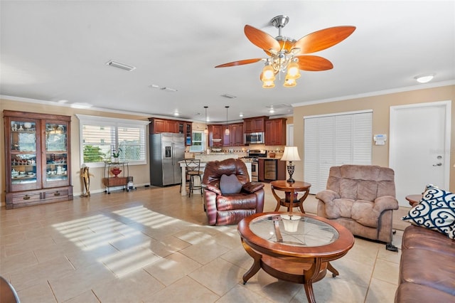 living room with ceiling fan, ornamental molding, and light tile patterned floors