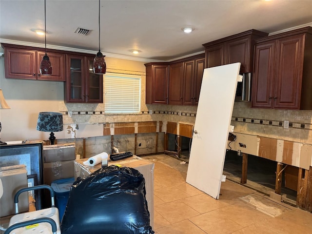 kitchen featuring backsplash, crown molding, decorative light fixtures, and light tile patterned flooring