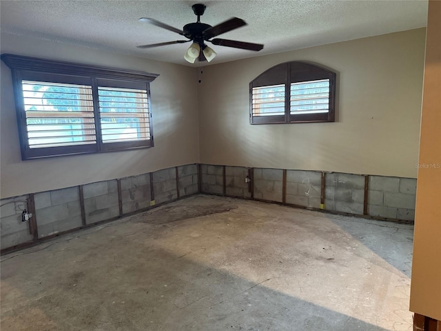 unfurnished room featuring concrete floors, a textured ceiling, and ceiling fan