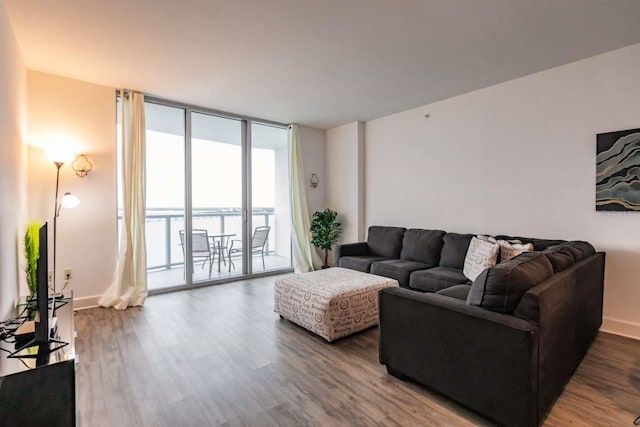 living room featuring wood-type flooring and floor to ceiling windows