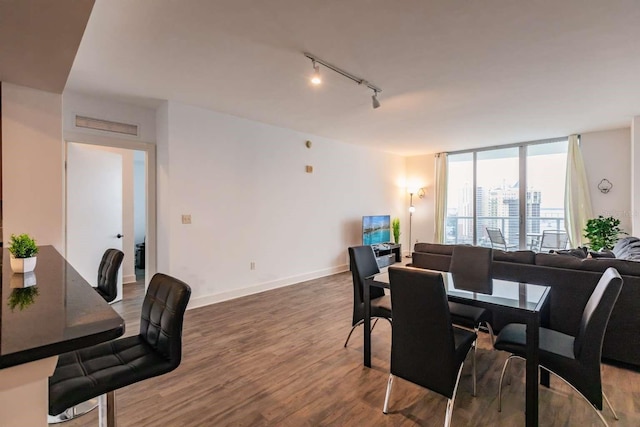 dining space featuring hardwood / wood-style flooring and track lighting