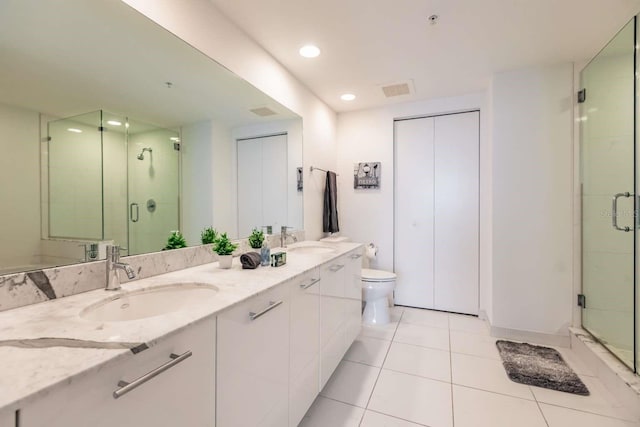 bathroom featuring vanity, a shower with shower door, toilet, and tile patterned flooring