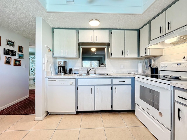 kitchen featuring tasteful backsplash, sink, white appliances, and light tile patterned floors