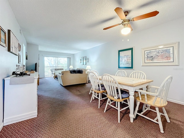 carpeted dining room featuring a textured ceiling and ceiling fan