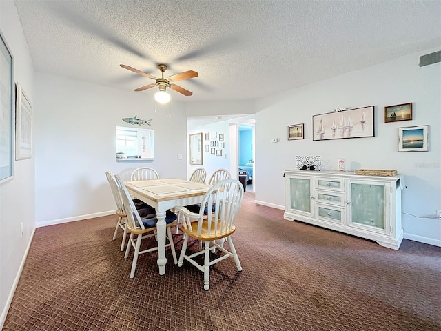 carpeted dining space with a textured ceiling and ceiling fan