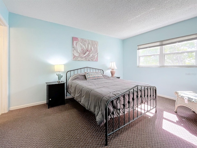 bedroom featuring a textured ceiling and carpet floors