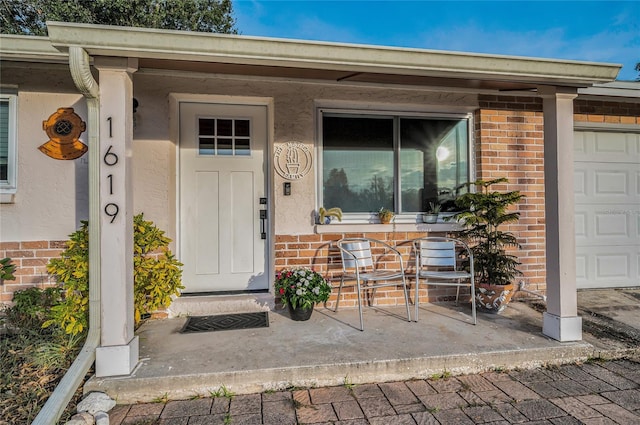 property entrance featuring a porch and a garage