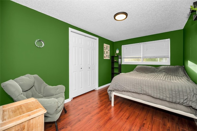 bedroom featuring hardwood / wood-style floors, a closet, and a textured ceiling