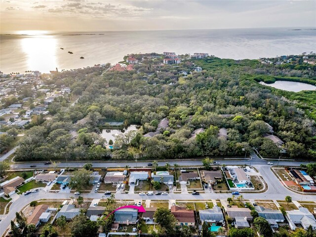 aerial view at dusk featuring a water view