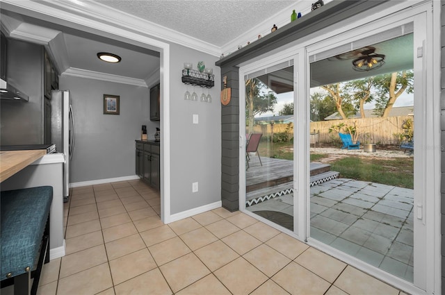 entryway with crown molding, a textured ceiling, and light tile patterned flooring