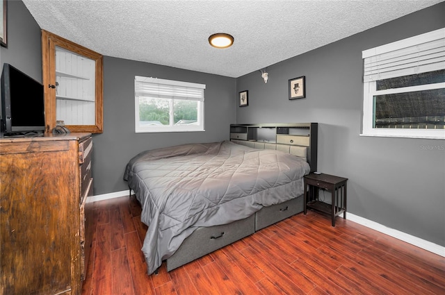 bedroom with dark wood-type flooring and a textured ceiling