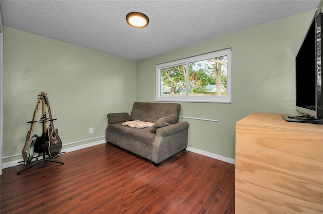 sitting room featuring dark hardwood / wood-style flooring and a textured ceiling