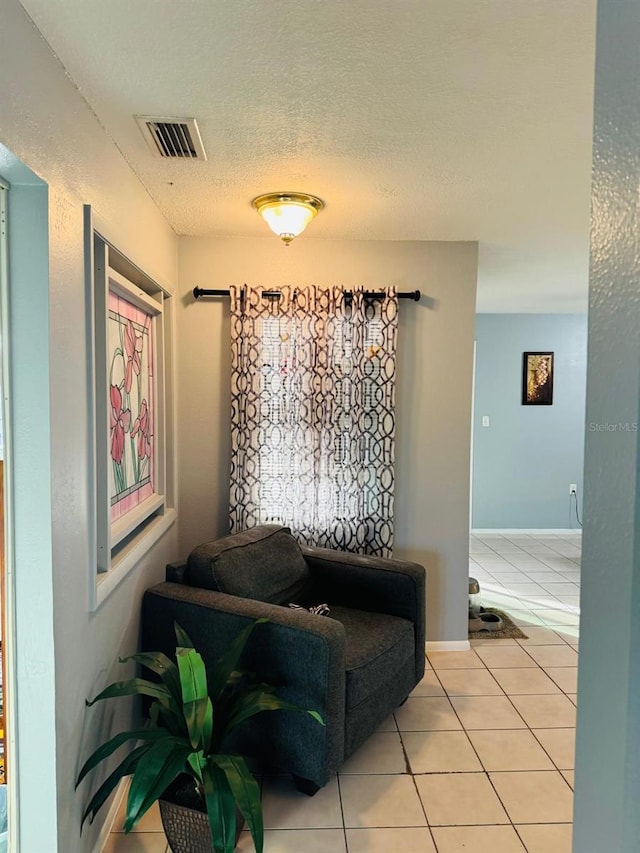 living area featuring light tile patterned flooring and a textured ceiling