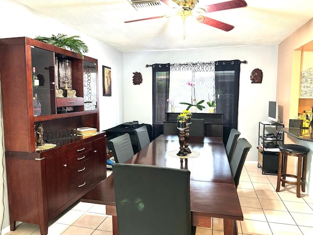 dining room featuring a textured ceiling, light tile patterned floors, and ceiling fan