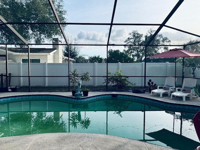 view of pool featuring glass enclosure and a patio area