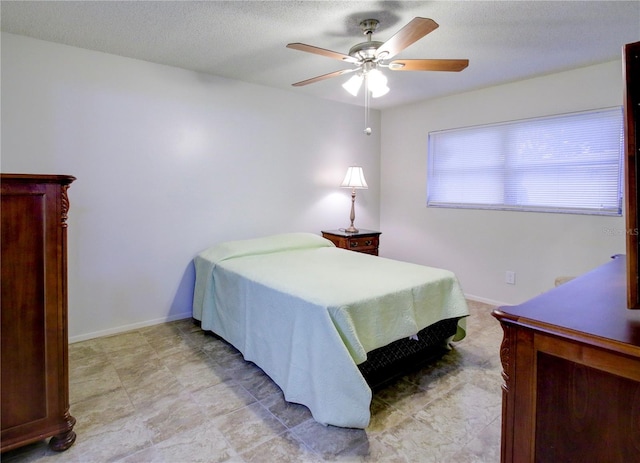 bedroom featuring ceiling fan and a textured ceiling