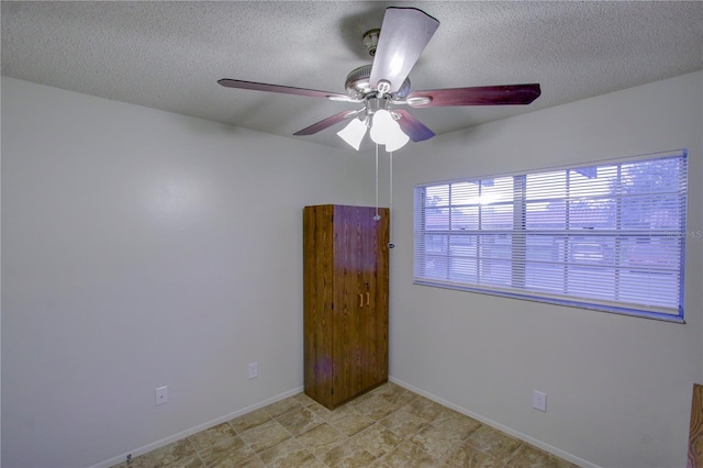 empty room featuring ceiling fan and a textured ceiling