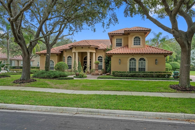 mediterranean / spanish house with a front yard