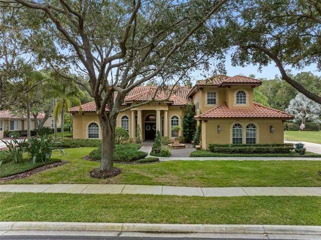 mediterranean / spanish house featuring a front yard