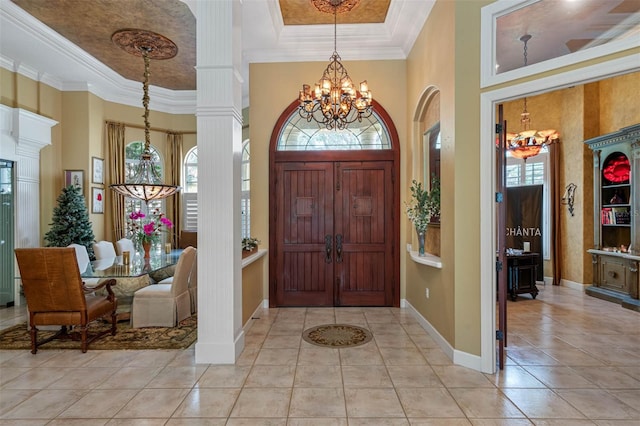 tiled foyer featuring crown molding, an inviting chandelier, plenty of natural light, and a high ceiling