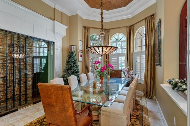 tiled dining area with ornamental molding and a towering ceiling