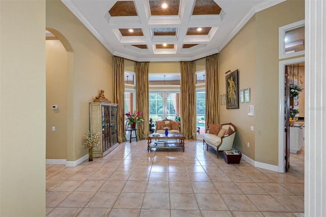 tiled foyer entrance featuring beam ceiling, ornamental molding, coffered ceiling, and a high ceiling