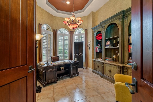 office featuring light tile patterned floors, a tray ceiling, ornamental molding, and an inviting chandelier