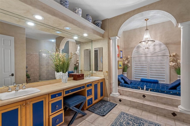 bathroom featuring a textured ceiling, a chandelier, ornate columns, vanity, and tile patterned flooring