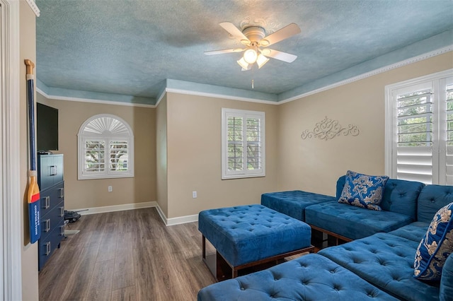 living room featuring a textured ceiling, crown molding, hardwood / wood-style flooring, and ceiling fan