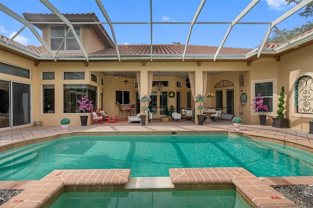 view of pool with ceiling fan, a patio area, and a lanai