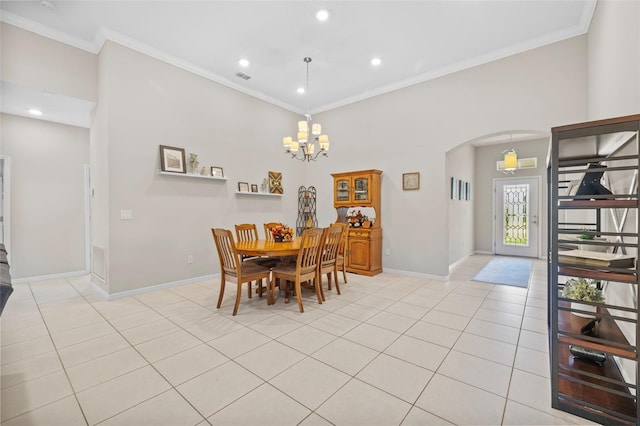 tiled dining room featuring ornamental molding and an inviting chandelier