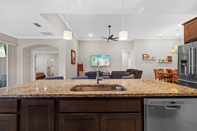 kitchen featuring light stone counters, stainless steel appliances, and sink