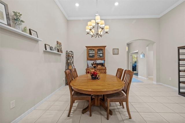 tiled dining area featuring crown molding, an inviting chandelier, and a high ceiling