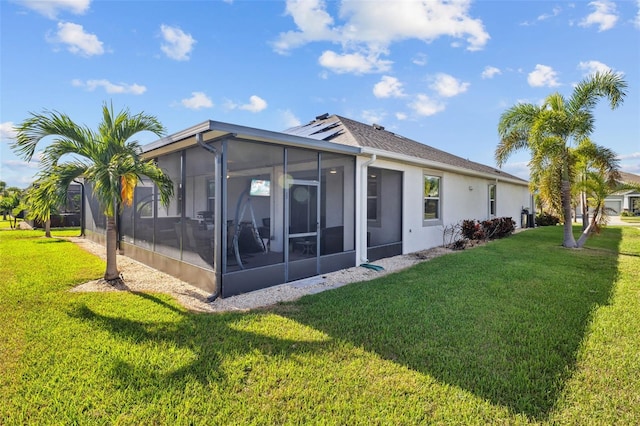 back of house featuring a lawn and a sunroom